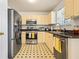 Functional kitchen with stainless steel appliances, classic cabinets, and patterned flooring at 11833 Spring Lake Way, Fayetteville, GA 30215