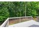 The back deck overlooks the landscaped yard and forest beyond at 6490 Ivey Hill Dr, Cumming, GA 30040