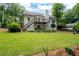 Rear elevation with a large yard, trees, and a walkout basement at 6490 Ivey Hill Dr, Cumming, GA 30040