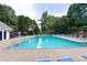 Community pool with plenty of lounge chairs and shade umbrellas at 6490 Ivey Hill Dr, Cumming, GA 30040