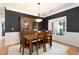 Elegant dining room featuring wainscoting, modern lighting, and a dark accent wall, creating a sophisticated dining experience at 6490 Ivey Hill Dr, Cumming, GA 30040