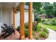 Cozy porch with wooden support columns, brick flooring, seating, and beautiful landscaping, perfect for relaxing outdoors at 6490 Ivey Hill Dr, Cumming, GA 30040