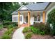 Inviting covered front porch with wood columns, a brick walkway, and charming floral accents for a welcoming entrance at 6490 Ivey Hill Dr, Cumming, GA 30040