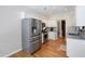 Contemporary kitchen with stainless steel appliances, white cabinetry, granite countertops, and hardwood floors, a chef's dream space at 6490 Ivey Hill Dr, Cumming, GA 30040