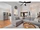 Stylish living room featuring hardwood floors, a comfortable gray sectional, and an open layout connecting to the kitchen and entry at 6490 Ivey Hill Dr, Cumming, GA 30040