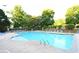 Sparkling community pool with lounge chairs surrounded by mature landscaping in a serene setting at 6490 Ivey Hill Dr, Cumming, GA 30040