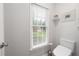 Bright half bath with toilet and window providing natural light, and a plant at 6490 Ivey Hill Dr, Cumming, GA 30040
