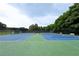 Outdoor tennis courts featuring well-maintained blue courts, green surroundings, and benches for relaxation at 6490 Ivey Hill Dr, Cumming, GA 30040