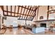 Spacious living room with hardwood floors, beamed ceilings, stone fireplace, and elegant chandelier lighting at 6851 Roswell Rd # 15, Atlanta, GA 30328