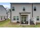Back exterior elevation features a covered patio with seating and a well-maintained lawn at 1542 Villageside Ct, Lawrenceville, GA 30043