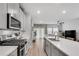 Open-concept kitchen with white countertops, stainless steel appliances, and a view into the living room at 1542 Villageside Ct, Lawrenceville, GA 30043