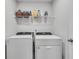Efficient laundry area with modern appliances and practical shelving for storage at 1542 Villageside Ct, Lawrenceville, GA 30043