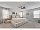 Bright and serene primary bedroom showcasing a king-size bed, ceiling fan, and ample natural light from multiple windows at 1542 Villageside Ct, Lawrenceville, GA 30043