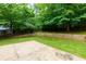 Well-maintained backyard featuring green grass, a concrete patio and mature trees at 5741 Stonekirk Walk Northwest, Acworth, GA 30101
