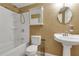 This bathroom includes a single sink vanity, framed mirror, shower and tub combo with shower caddy at 5741 Stonekirk Walk Northwest, Acworth, GA 30101