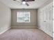 This bedroom has neutral walls, carpeted flooring, a ceiling fan, and a window with blinds for natural light at 5741 Stonekirk Walk Northwest, Acworth, GA 30101