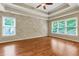 Primary bedroom with hardwood floors, ceiling fan, and accent wall at 5741 Stonekirk Walk Northwest, Acworth, GA 30101