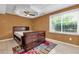 This bedroom features a dresser, ceiling fan, tile floors, and large window with views of the trees at 5741 Stonekirk Walk Northwest, Acworth, GA 30101