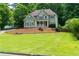 Lovely two-story home with a cozy front porch and neatly manicured lawn, surrounded by mature trees and greenery at 5741 Stonekirk Walk Northwest, Acworth, GA 30101
