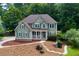 Beautiful two-story home with a covered porch, nestled in a lush green landscape, showcasing charm and curb appeal at 5741 Stonekirk Walk Northwest, Acworth, GA 30101
