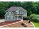 Elegant two-story home with a welcoming front porch, complemented by lush greenery and mature trees at 5741 Stonekirk Walk Northwest, Acworth, GA 30101