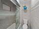 Bathroom with tiled shower, glass doors, and a blue hanging plant in a pot at 834 Lake Hollow Sw Blvd, Marietta, GA 30064