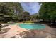 Community swimming pool surrounded by mature trees and comfortable lounge seating provides a relaxing outdoor space at 834 Lake Hollow Sw Blvd, Marietta, GA 30064