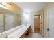 Bright bathroom with a double sink vanity and a doorway to a shower/tub combination at 1057 Cotton Oak Dr, Lawrenceville, GA 30045