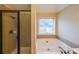 Bathroom featuring a soaking tub, glass shower, and a window for natural light at 1057 Cotton Oak Dr, Lawrenceville, GA 30045