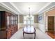 Formal dining room featuring a dark wood table, china cabinet, and elegant chandelier at 1057 Cotton Oak Dr, Lawrenceville, GA 30045
