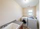 Laundry room featuring white washer and dryer, granite countertop, and tile floors at 1057 Cotton Oak Dr, Lawrenceville, GA 30045