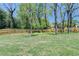 Spacious backyard with green grass, mature trees, and a wooden fence at 1807 N Chestnut Grove Dr, Marietta, GA 30066