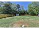 Large, fenced backyard with grass, mature trees, and shed at 1807 N Chestnut Grove Dr, Marietta, GA 30066