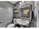Stylish powder room featuring a pedestal sink, decorative shelves, and elegant gold-toned mirror at 1807 N Chestnut Grove Dr, Marietta, GA 30066
