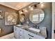 Bathroom with double sinks, gray walls, modern lighting, and decorative mirror at 1807 N Chestnut Grove Dr, Marietta, GA 30066