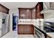 Modern kitchen featuring dark cabinets, stainless steel appliances, and view to the dining and kitchen areas at 1807 N Chestnut Grove Dr, Marietta, GA 30066