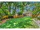 Expansive backyard featuring lush green grass, tall mature trees and a wooden fence, creating a serene outdoor oasis at 261 Ormond Se St, Atlanta, GA 30315