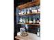 Stylish bar area with marble countertop, dark tile backsplash, and open shelving stocked with various liquors at 261 Ormond Se St, Atlanta, GA 30315