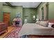 Bedroom with green walls, fireplace, Oriental rug, and view to another door at 261 Ormond Se St, Atlanta, GA 30315
