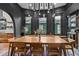 Open-concept dining area with modern chandelier, dark walls, and view into kitchen featuring wood cabinets at 261 Ormond Se St, Atlanta, GA 30315