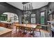 Open dining room with modern chandelier, black walls, and access to the kitchen with a wooden island at 261 Ormond Se St, Atlanta, GA 30315