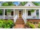 Inviting front porch with swing, seating, ferns, and brick stairs leading to a wood door at 261 Ormond Se St, Atlanta, GA 30315