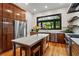 Modern kitchen featuring custom wood cabinets, stainless steel appliances, and a marble island with seating at 261 Ormond Se St, Atlanta, GA 30315