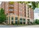 A multi-story brick building with balconies, lush landscaping, and street access, offering urban living at 326 Roswell Se St # 706, Marietta, GA 30060