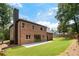 Beautiful backyard with a brick home, chimney, and lush green lawn, perfect for outdoor living at 3711 Mountain Cove Rd, Snellville, GA 30039