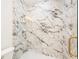 Elegant bathroom with marble tile, modern shower fixtures, and a glass door at 3711 Mountain Cove Rd, Snellville, GA 30039