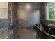 Luxurious bathroom with a black standalone tub, a sleek shower, and chic black marble tiling at 3711 Mountain Cove Rd, Snellville, GA 30039