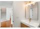 Stylish powder room with modern vanity, sleek mirror, and adjacent entry to the staircase at 3711 Mountain Cove Rd, Snellville, GA 30039