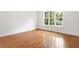 Bright bedroom features gleaming hardwood floors, white trim, and a large window for ample natural light at 3711 Mountain Cove Rd, Snellville, GA 30039