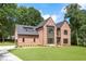 Contemporary brick home with an attached garage, manicured lawn, and stylish black-framed windows at 3711 Mountain Cove Rd, Snellville, GA 30039